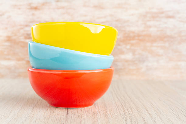 istock Ceramic bowl assorted colors on wooden background 1136006313