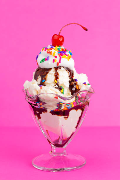 istock Vanilla Sundae with Sprinkles and Chocolate Sauce on a Pink Background 1136006456