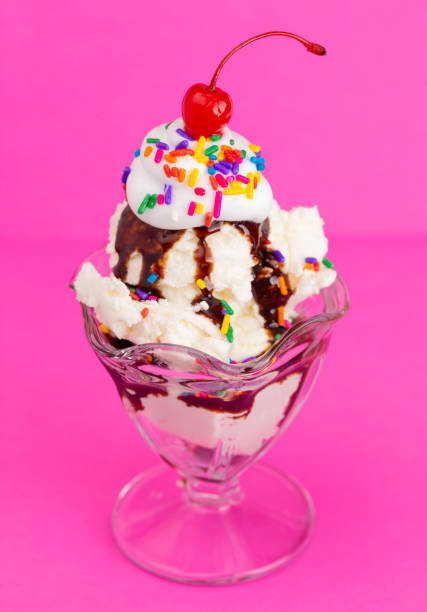 istock Vanilla Sundae with Sprinkles and Chocolate Sauce on a Pink Background 1136006617