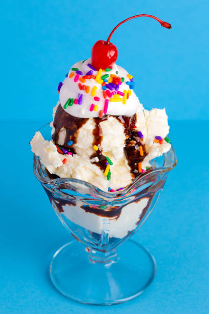 istock A Vanilla Sundae with Rainbow Sprinkles on a Blue Background 1136006679