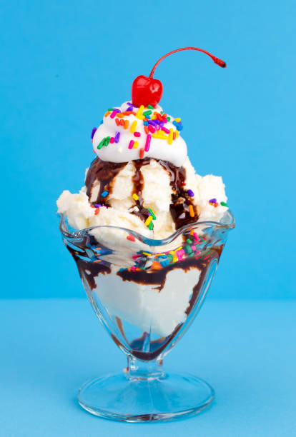istock A Vanilla Sundae with Rainbow Sprinkles on a Blue Background 1136006680