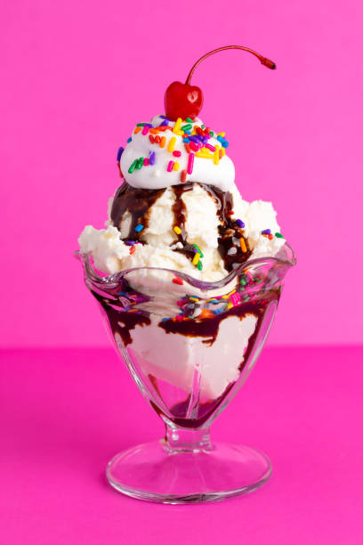 istock Vanilla Sundae with Sprinkles and Chocolate Sauce on a Pink Background 1136006681