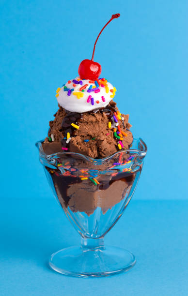 istock A Chocolate Sundae with Rainbow Sprinkles on a Blue Background 1136008445