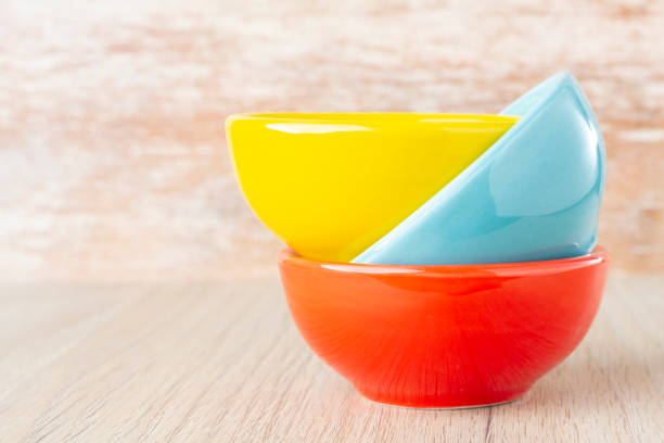 istock Ceramic bowl assorted colors on wooden background 1136008470