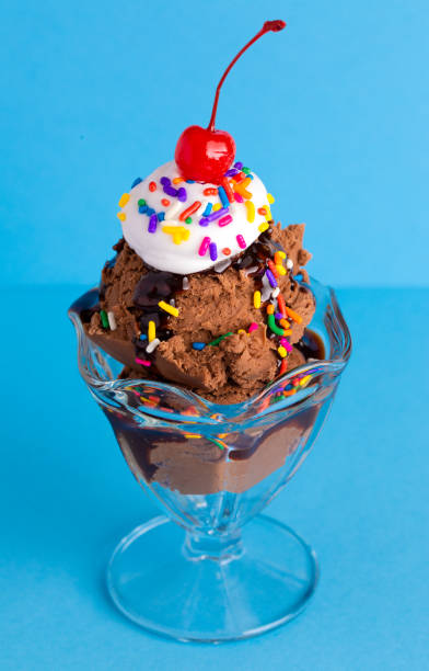 istock A Chocolate Sundae with Rainbow Sprinkles on a Blue Background 1136008621