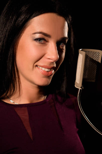 istock Young woman singer in front of microphone. 1136008827