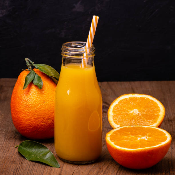 istock bottle with orange juice and drinking straw ready to drink 1136008957