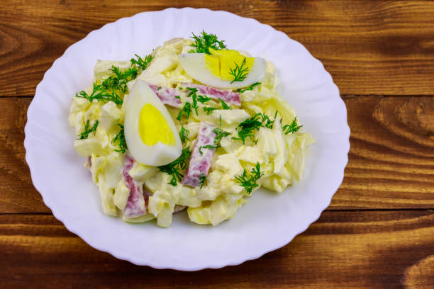 salad with chinese cabbage, onion, sausage, eggs and mayonnaise on wooden table - 5943 imagens e fotografias de stock
