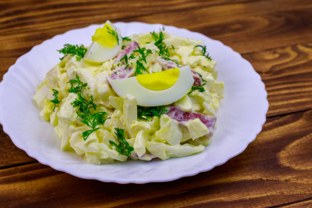 ensalada con col china, cebolla, salchicha, huevos y mayonesa sobre mesa de madera - 5954 fotografías e imágenes de stock