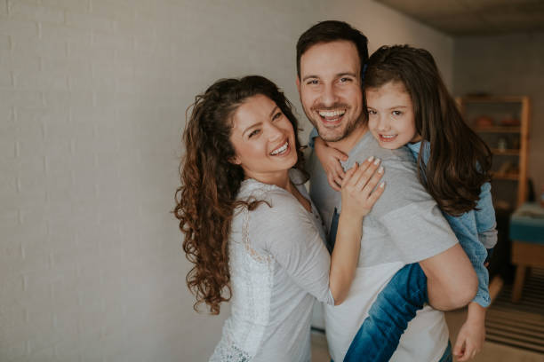 istock Always happy together. Young loving father carrying his daughter and smiling while spending free time at home. 1136011195