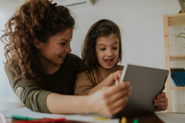 istock Young beautiful mom and child with tablet having a good time smiling and learning. 1136011262