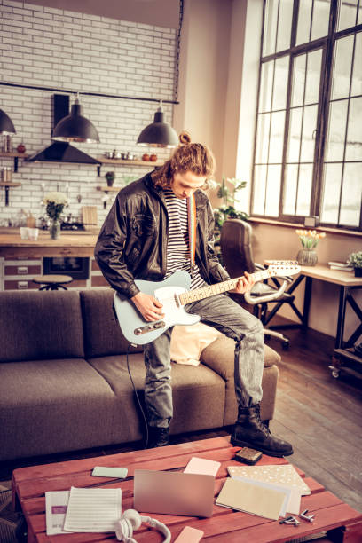 istock Rock music lover wearing leather boots playing the guitar 1136011668