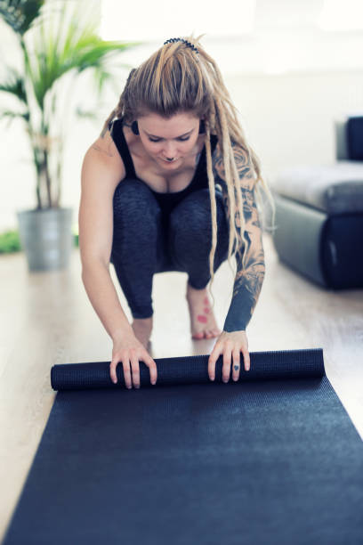 istock Young tattooed woman doing yoga training at home 1136014417
