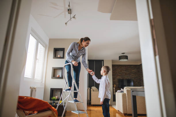 filho novo que aprende como mudar uma ampola com matriz - changing lightbulb - fotografias e filmes do acervo