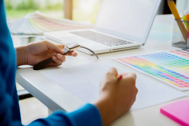 istock Graphic design and color swatches and pens on a desk. Architectural drawing with work tools and accessories. 1136017339