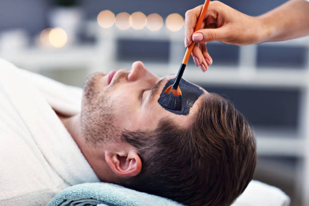 スパサロンで顔をしているハンサムな男 - massaging spa treatment stone massage therapist ストックフォトと画像