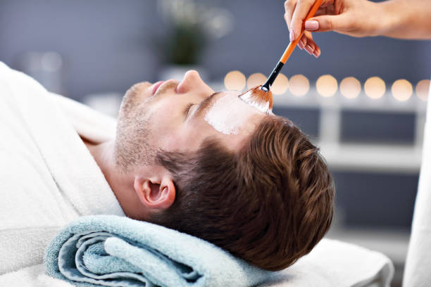 istock Handsome man having facial in spa salon 1136017516