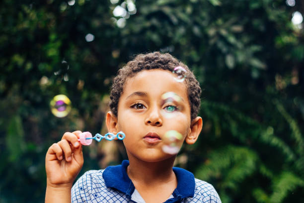 garçon jouant des bulles de savon - bubble wand child outdoors bubble photos et images de collection