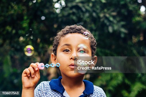 istock Boy playing soap bubbles 1136017543