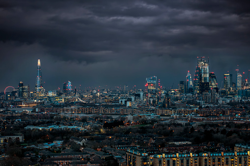 The skyline of London, UK with dark clouds in the sky