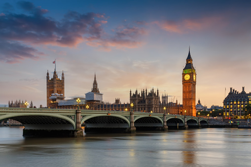 The Westminster Palace and the Big Ben clocktower at the river Thames in London, UK, just after sunset