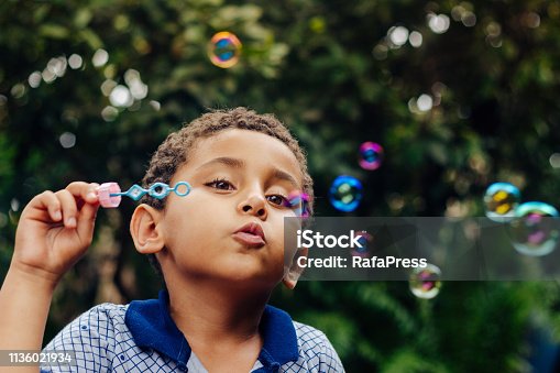 istock Boy playing soap bubbles 1136021934