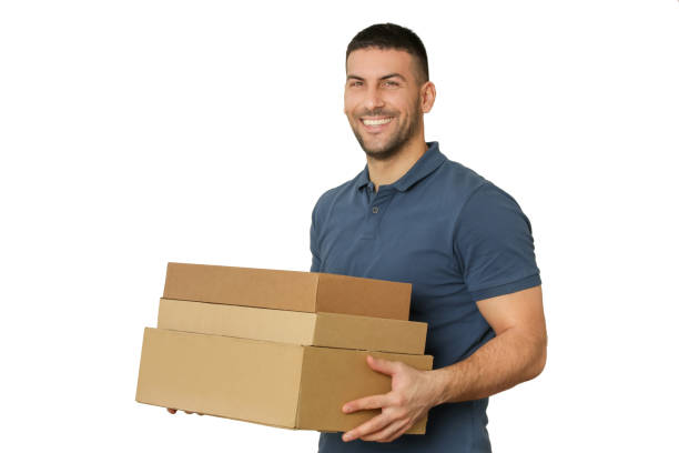 istock Young handsome worker holding cardboard boxes, studio shot isolated on white 1136023144