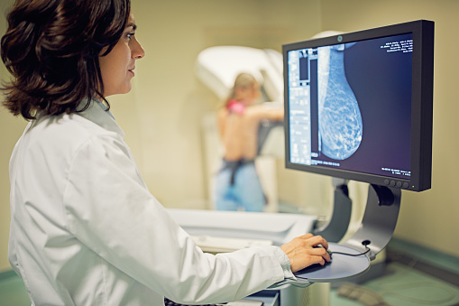 El médico está trabajando con un escáner de rayos X para mamografía en el hospital photo