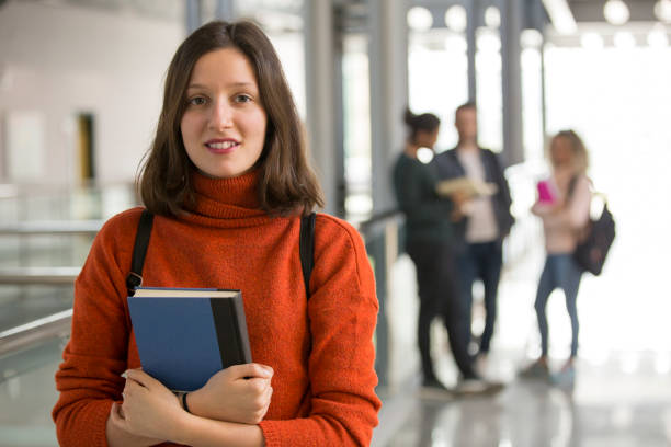 istock Portrait of smiling university student standing in corridor during break 1136028480