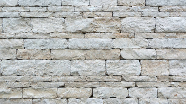 Gray dry stone wall of coarse natural stones Gray dry stone wall of coarse, rectangular hewn natural stones in closeup roughhewn stock pictures, royalty-free photos & images