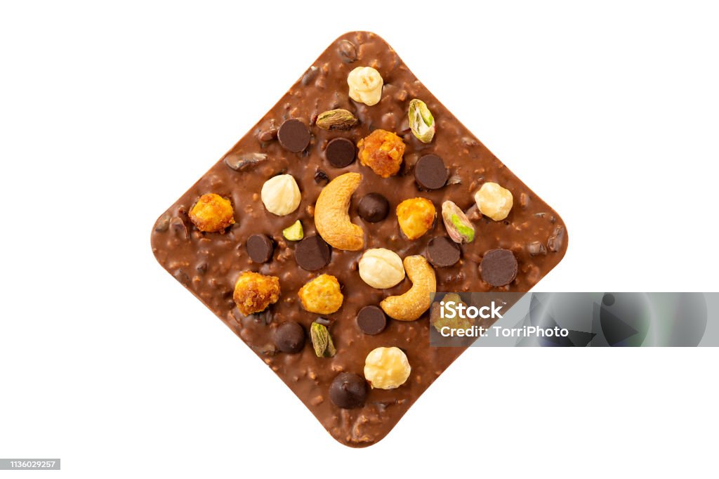 Milk chocolate bar with hazelnuts, pistachio and cashew isolated on white background Milk chocolate bar with hazelnuts, pistachio and cashew isolated on white background. Luxury handmade chocolate Baked Pastry Item Stock Photo