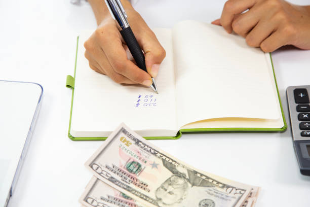 istock business woman doing account in office. dollar pen and notebook 1136029307