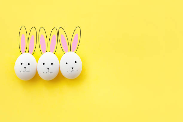 istock three funny drawn Bunny from chicken eggs on a yellow background 1136029499