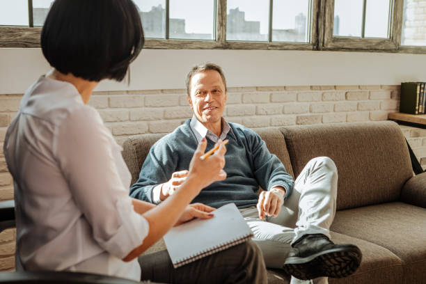 istock Smiling good-looking man having pleasant conversation with dark-haired doctor 1136029658