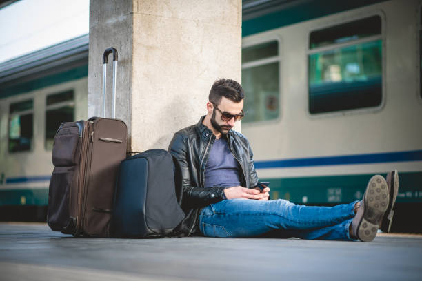 homem que senta-se na plataforma da estação de estrada de ferro - bag boredom bored man casual - fotografias e filmes do acervo