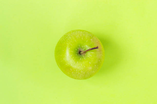 istock Green apple isolated on green background 1136031541