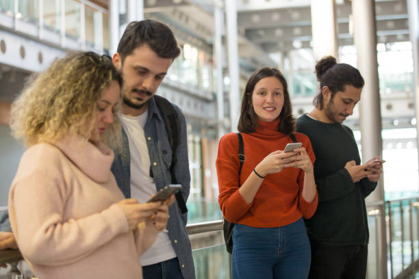 istock Group of students in corridor with smartphone 1136031744