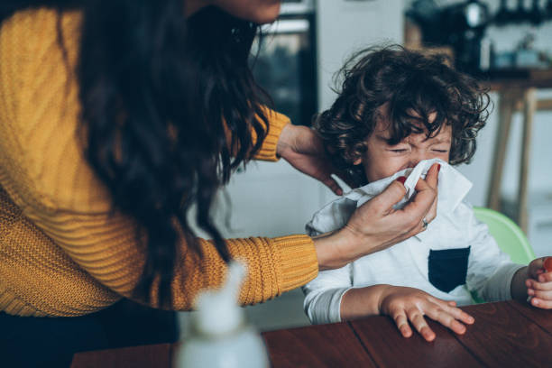 istock Mother helping son to blow his nose 1136031915