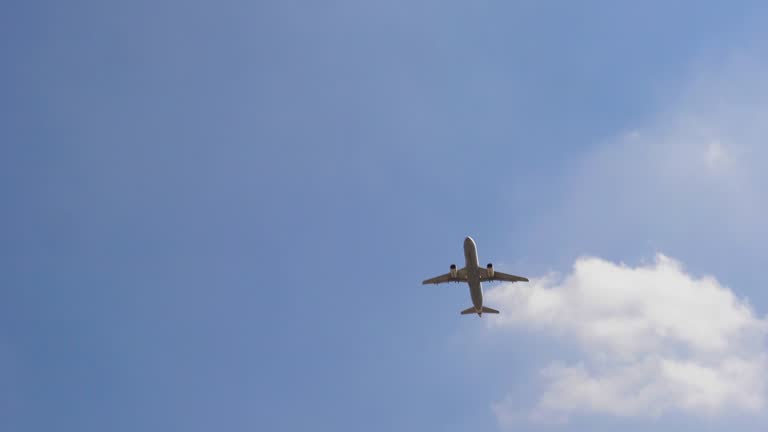 Plane flying over head on blue sky, 4к. Airplane takeoff into the sky.