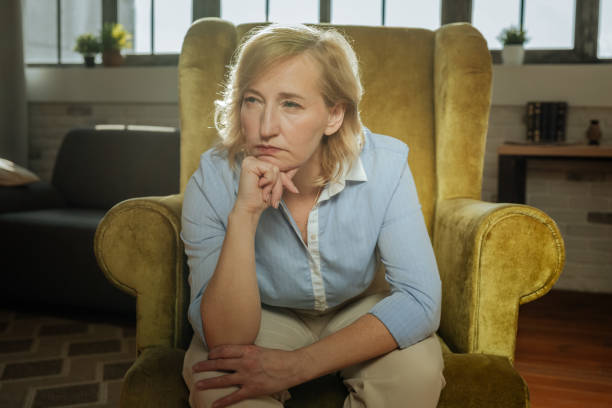 istock Old short-haired blonde woman bending over while sitting 1136033178