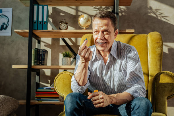 istock Smiling short-haired man in blue jeans holding a pill 1136033189