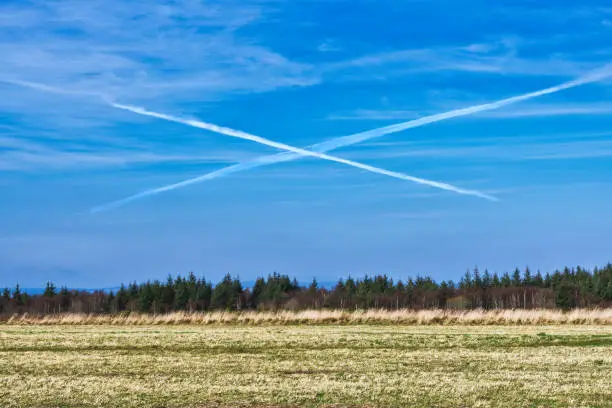 Here we see the historic site of Culloden battlefield, near Inverness, Scotland.  On April 16 1746, the Jacobite army led by ‘Bonnie Prince Charlie (Charles Edward Stuart)’ suffered defeat here, to the British Army led by the Duke of Cumberland.  In the sky are two chemtrails, or vapour trails, from nearby aircraft.  The appear to make the colours of the Scottish flag (Saltire).  Ironically the battlefield was the place Scottish Independence failed.
