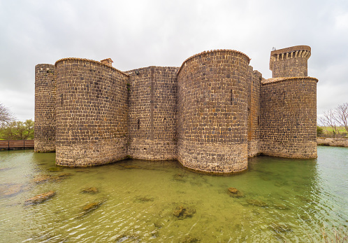 Vulci, Italy - 10 March 2019 - The medieval palace of Vulci, now statal museum, with Devil's bridge in stone. Vulci is an etruscan ruins city in Lazio region, on the Fiora river between Montalto di Castro and Canino. Here a view of the building.