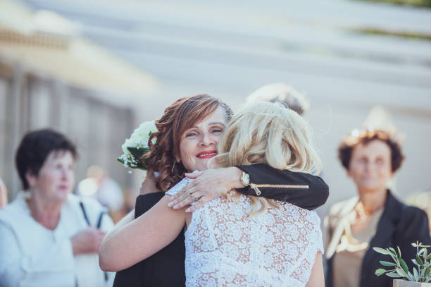 Smiling Mother of the Bride Hugging Bride.