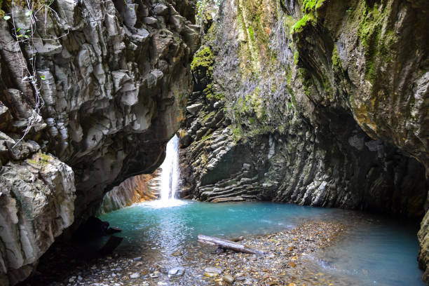 dans la grotte est un lac bleu et une cascade au sommet d'une falaise - cave fern flowing forest photos et images de collection