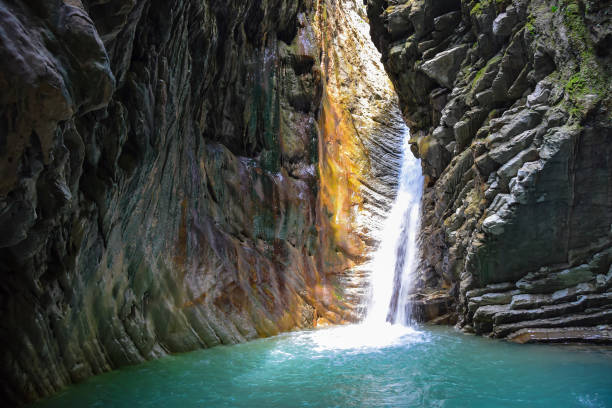 dans la grotte est un lac bleu et une cascade au sommet d'une falaise - cave fern flowing forest photos et images de collection