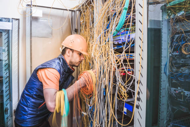 istock A technician commutes many trouble-free wires in the data center server room. Engineer repair broken internet connection. A professional internet campaign worker serves a rack with a central route. 1136043147