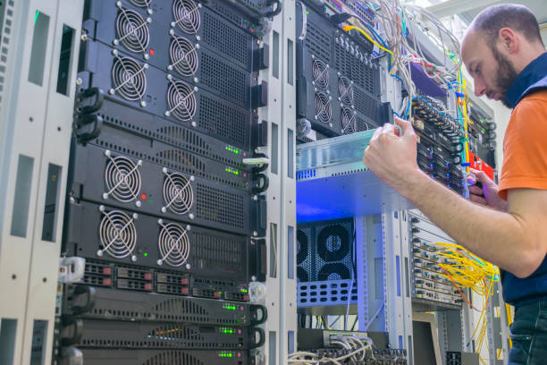 istock A technician repairs the central router. A man works in a server room. System administrator installs a new server in a modern data center. 1136043179