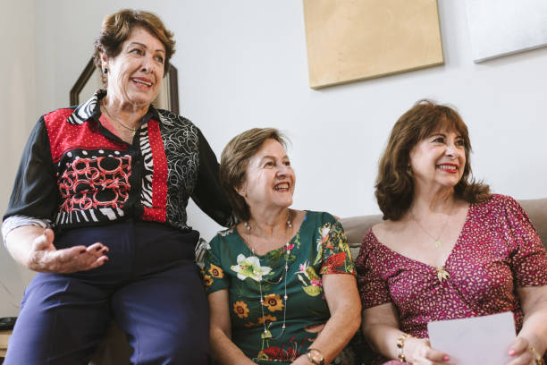 istock Three happy mature women sitting on sofa 1136043563