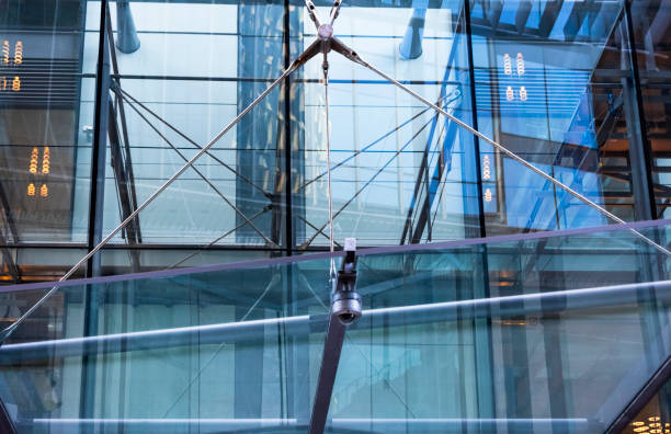 istock Closeup glass office building metal fastening and security camera, background with copy space 1136044909